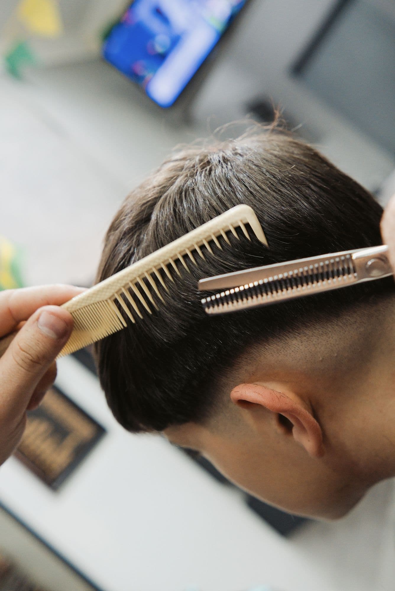Barbeiro sextando o cabelo do cliente com pente