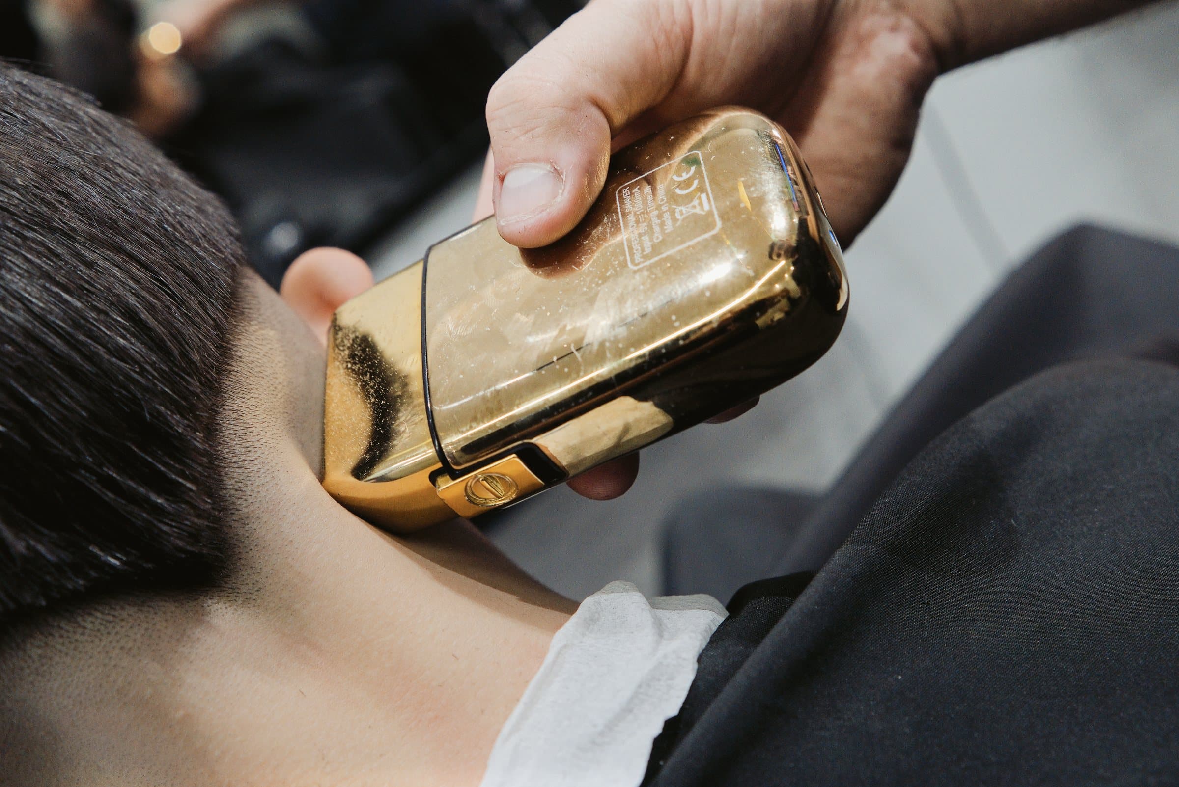Detalhe de máquina de acabamento dourada usada em um atendimento na Cortello Barber Shop